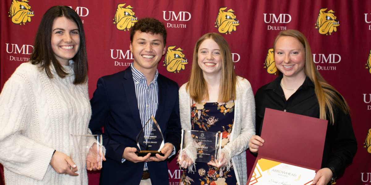 Four students holding their leadership awards