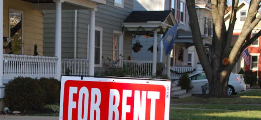 Photo of a house with a 'For Rent' sign in front.